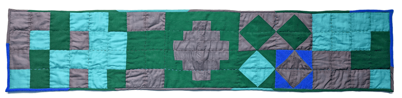photograph of a quilted wall hanging made using the quilt bot, in cool colours
