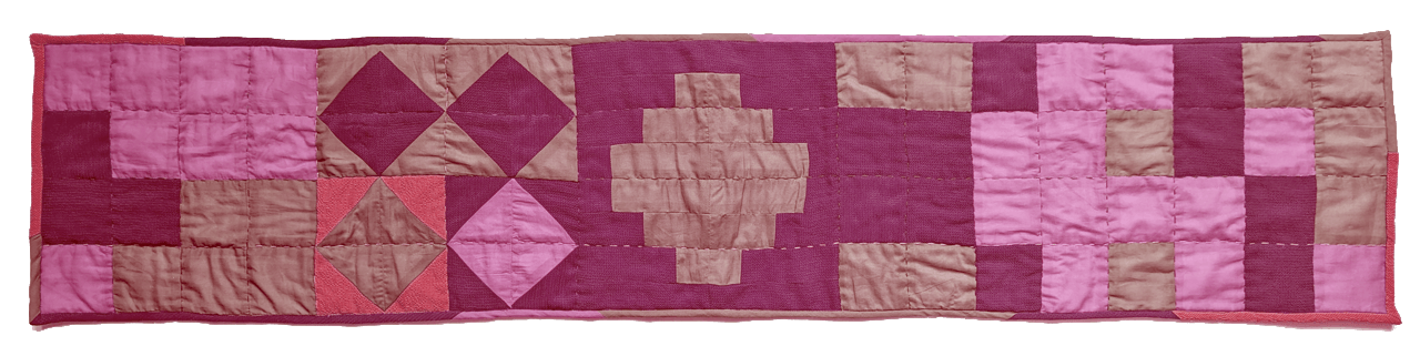 photograph of a quilted wall hanging made using the quilt bot, in shades of pink